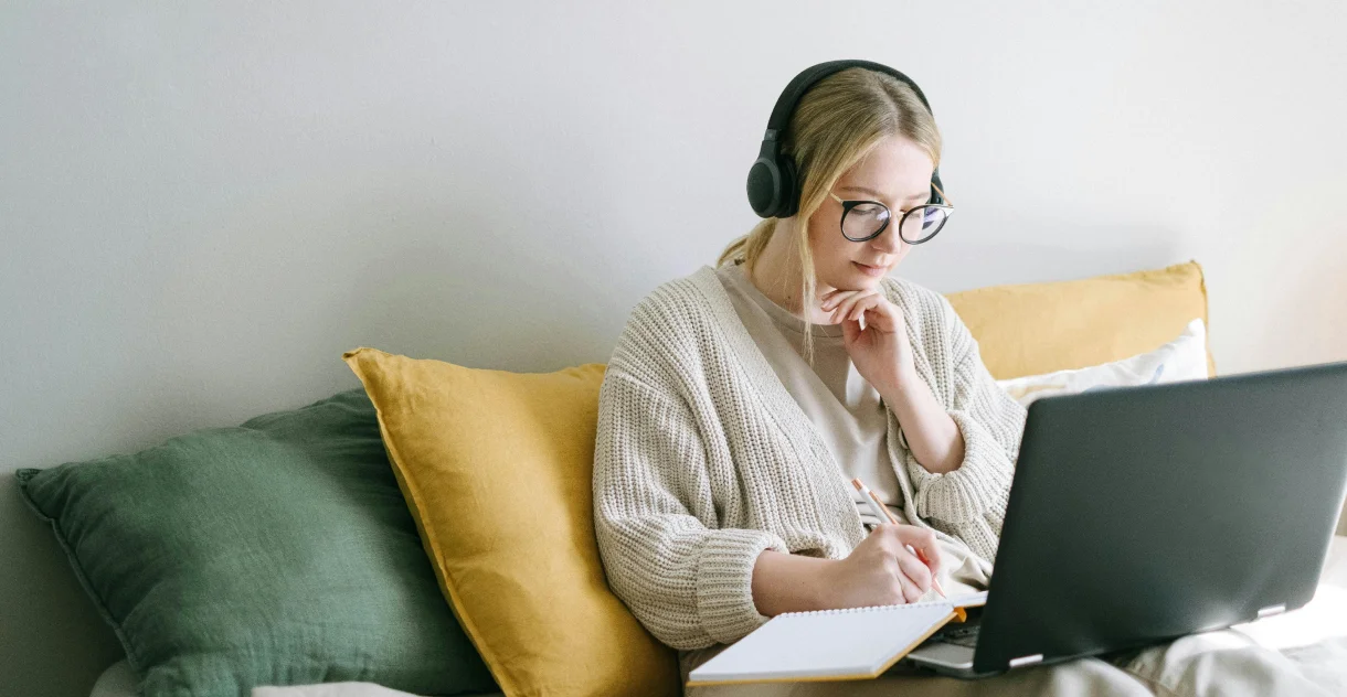 Woman using headphones while thinking of ideas for new website content