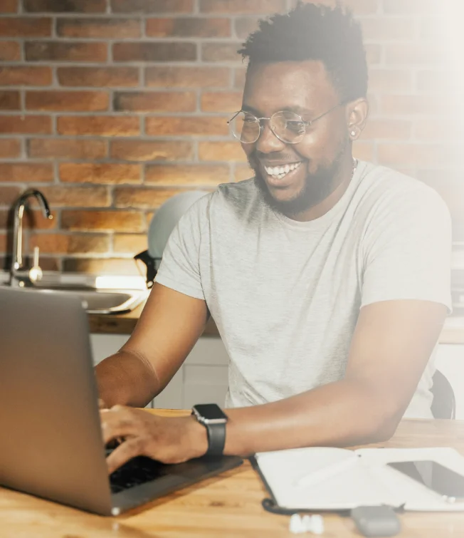 Male in grey T shirt using his laptop to update website content