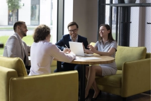 A digital marketing SEO team gathers in a round table discussing strategies to improve Google Business Profile visibility of their personal injury law firm clients.